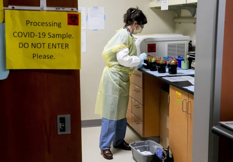 Lab technician Leslie Lazar Thorn starts to process blood samples from patients sick with COVID-19, at Harborview Medical Center in Seattle. The... (Erika Schultz / The Seattle Times)
