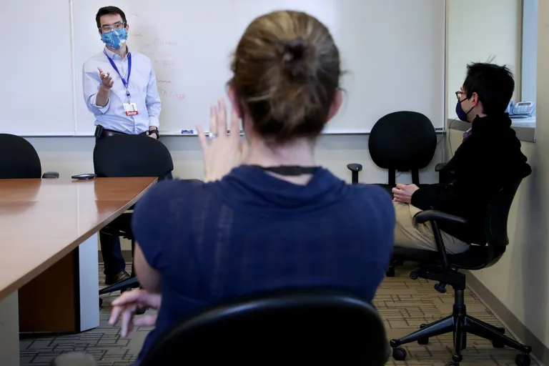Dr. Mark Wurfel, left, a critical-care physician, talks with doctors Carmen Mikacenic and Eric Morrell at Harborview Medical Center. (Erika Schultz / The Seattle Times)